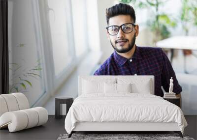 Happy Indian business man in glasses at the office. Wall mural